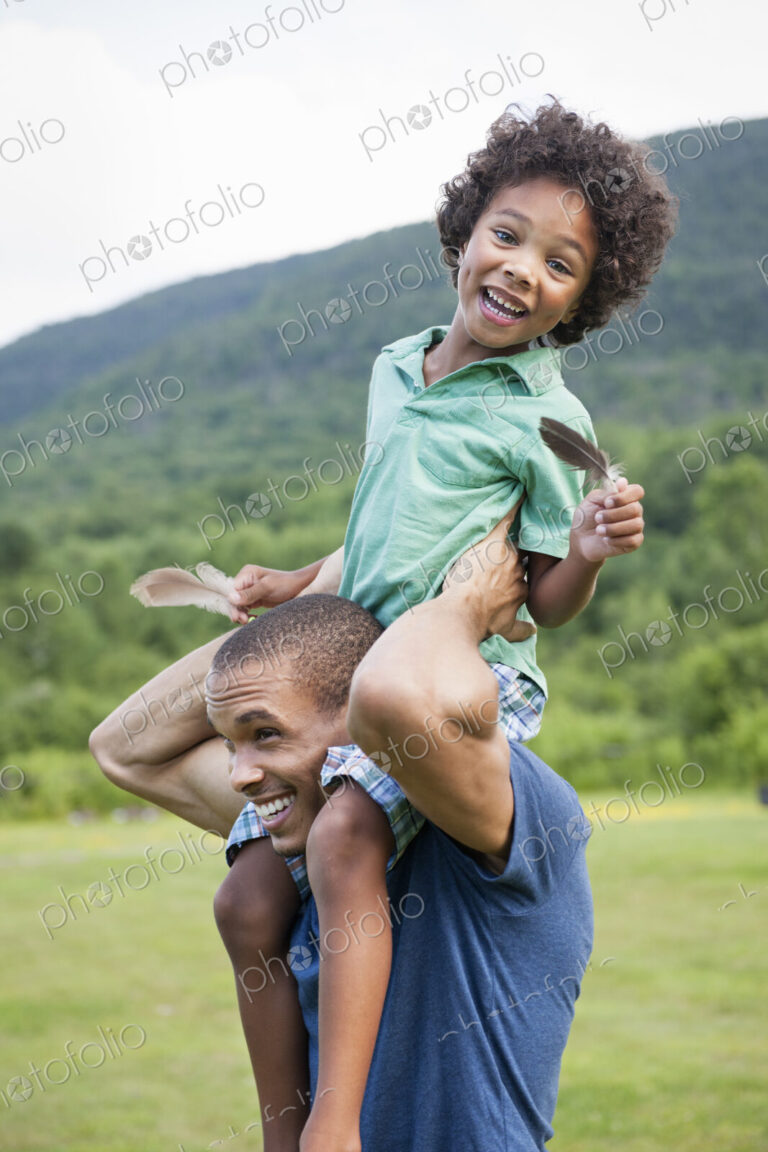 A father lifting his son up onto his shoulders.