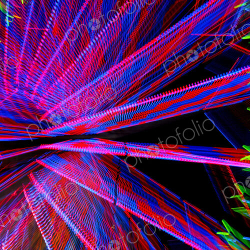 A ferris wheel at night, light patterns, red, blue and green A ferris wheel at night, light patterns, red, blue and green