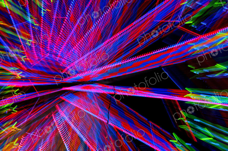 A ferris wheel at night, light patterns, red, blue and green