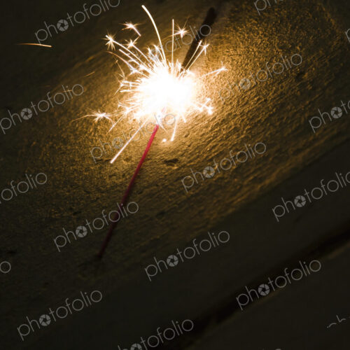 A firework sparkler on the ground, on a sandy beach. A firework sparkler on the ground, on a sandy beach.