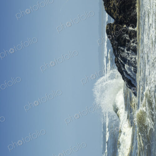 A fisherman on the rocky shore, fishing, waves breaking on shore. A fisherman on the rocky shore, fishing, waves breaking on shore.
