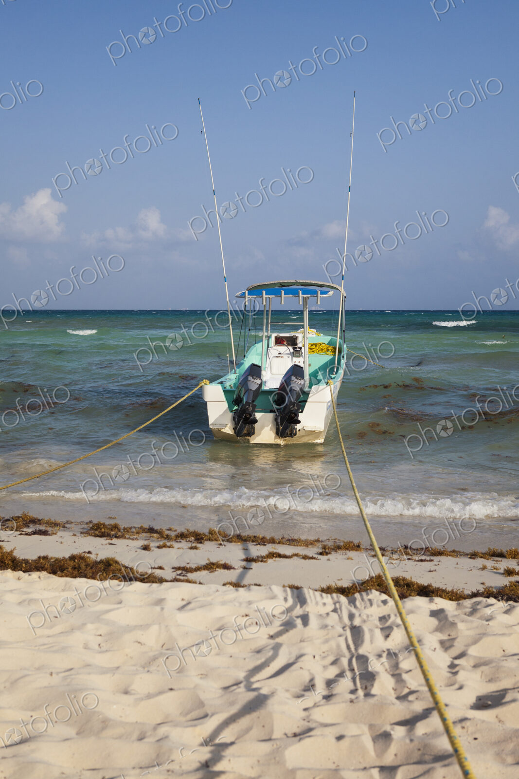 A fishing boat anchored at the edge of the water,on the beach