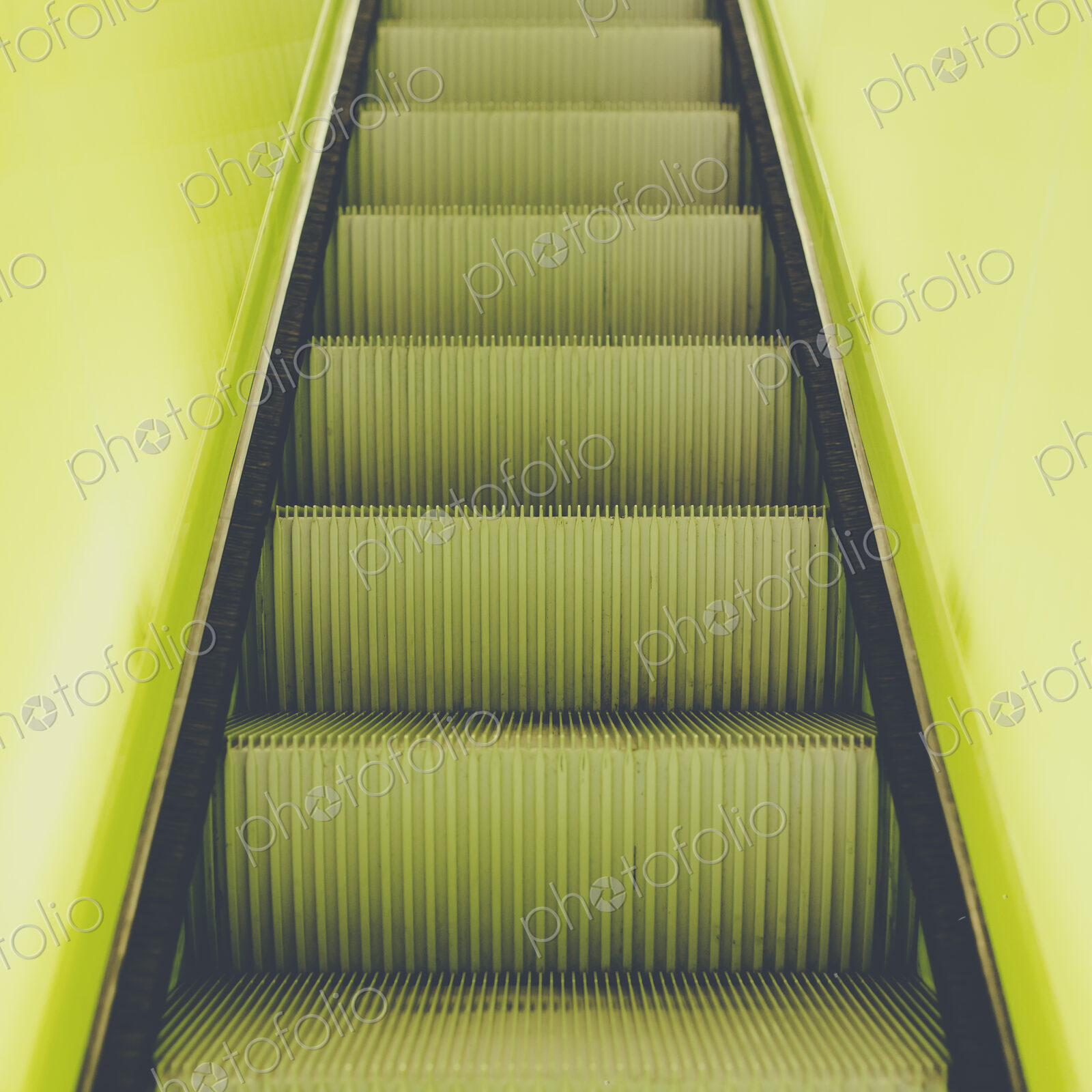 A flight of steps, an escalator with a yellow painted border stripe on each side.
