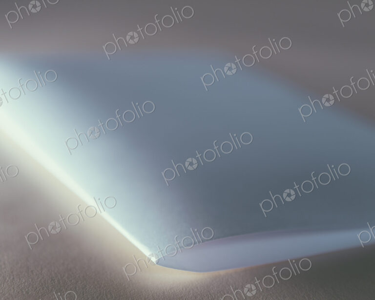 A folded piece of white recycled paper, close up.