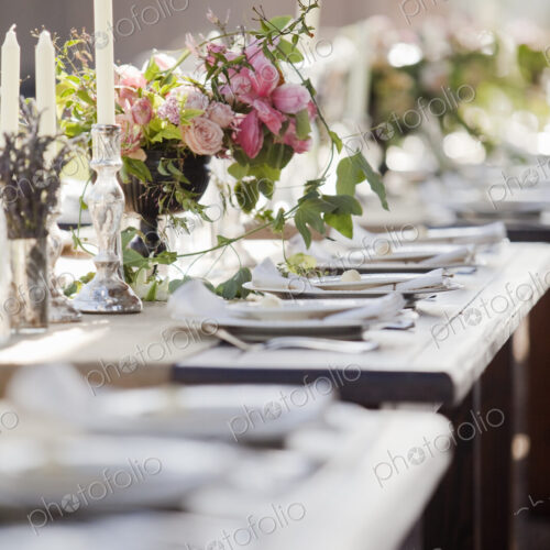 A formal wedding breakfast table, laid for a feast. Fresh flowers in the centre. A formal wedding breakfast table, laid for a feast. Fresh flowers in the centre.