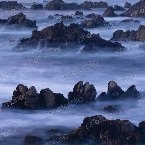 A four minute time exposure of ocean surf and coast rocks.