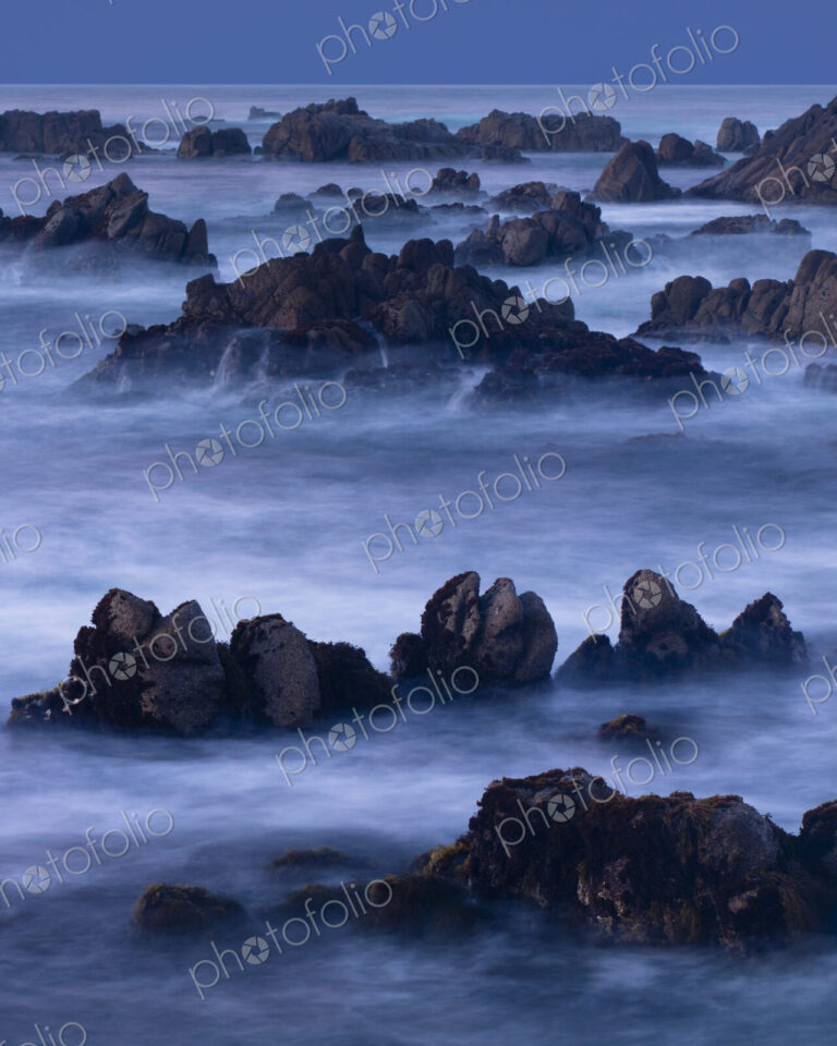 A four minute time exposure of ocean surf and coast rocks.