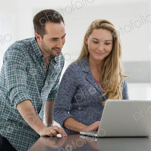 A fresh white building interior, flooded with light. A couple at a table looking at a… A fresh white building interior, flooded with light. A couple at a table looking at a…