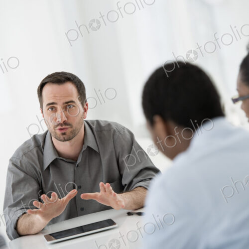 A fresh white building interior, flooded with light. A group of four people, two men… A fresh white building interior, flooded with light. A group of four people, two men…