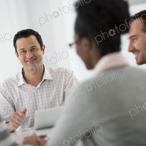 A fresh white building interior, flooded with light. A group of four people, two men… A fresh white building interior, flooded with light. A group of four people, two men…