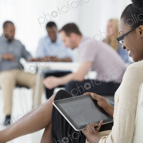 A fresh white building interior, flooded with light. A group of people meeting. One… A fresh white building interior, flooded with light. A group of people meeting. One…