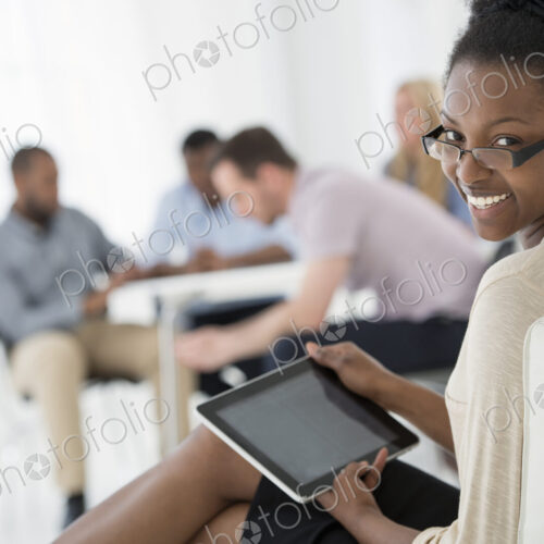 A fresh white building interior, flooded with light. A group of people meeting. One… A fresh white building interior, flooded with light. A group of people meeting. One…