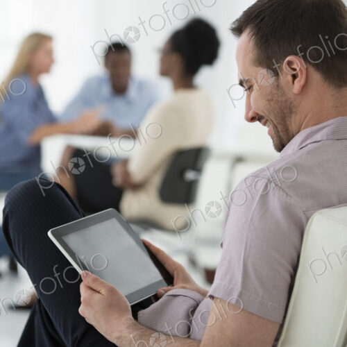 A fresh white building interior, flooded with light. A group of people meeting. One… A fresh white building interior, flooded with light. A group of people meeting. One…