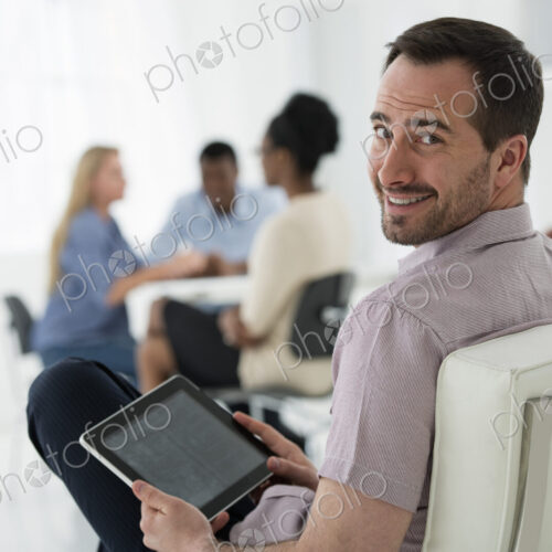 A fresh white building interior, flooded with light. A group of people meeting. One… A fresh white building interior, flooded with light. A group of people meeting. One…