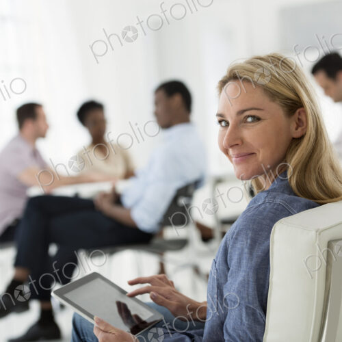 A fresh white building interior, flooded with light. A group of people meeting. One… A fresh white building interior, flooded with light. A group of people meeting. One…