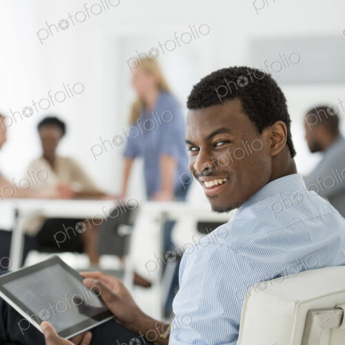 A fresh white building interior, flooded with light. A group of people meeting. One… A fresh white building interior, flooded with light. A group of people meeting. One…