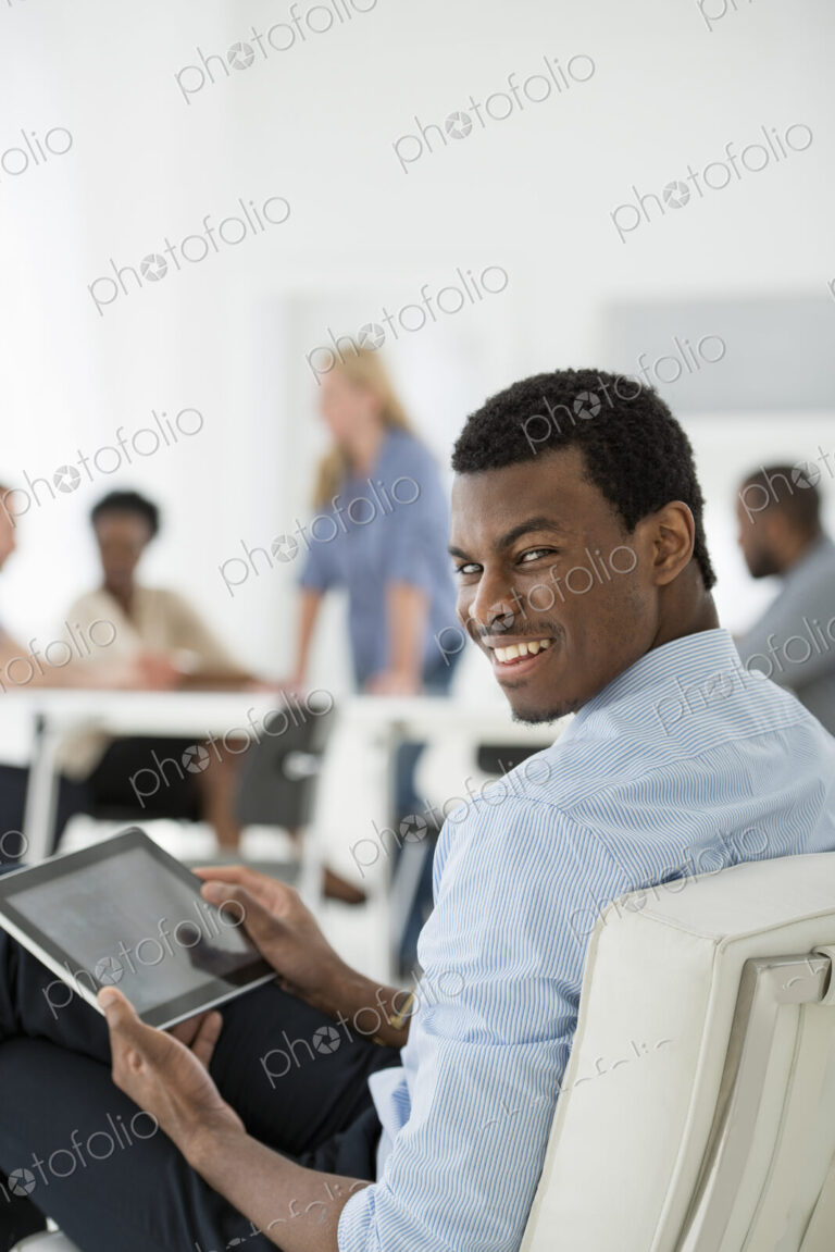 A fresh white building interior, flooded with light. A group of people meeting. One…