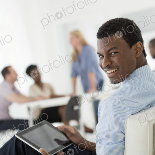 A fresh white building interior, flooded with light. A group of people meeting. One… A fresh white building interior, flooded with light. A group of people meeting. One…