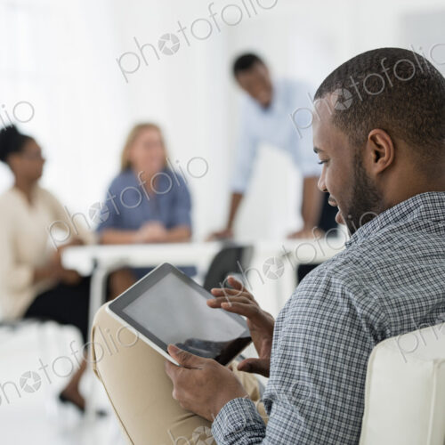 A fresh white building interior, flooded with light. A group of people meeting. One… A fresh white building interior, flooded with light. A group of people meeting. One…