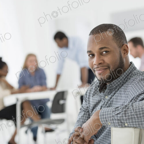 A fresh white building interior, flooded with light. A group of people meeting. One… A fresh white building interior, flooded with light. A group of people meeting. One…