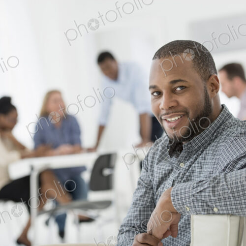 A fresh white building interior, flooded with light. A group of people meeting. One… A fresh white building interior, flooded with light. A group of people meeting. One…