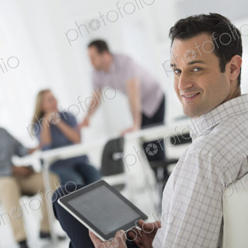 A fresh white building interior, flooded with light. A group of people meeting. One… A fresh white building interior, flooded with light. A group of people meeting. One…