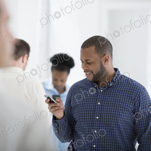 A fresh white building interior, flooded with light. A group of people, one man using…