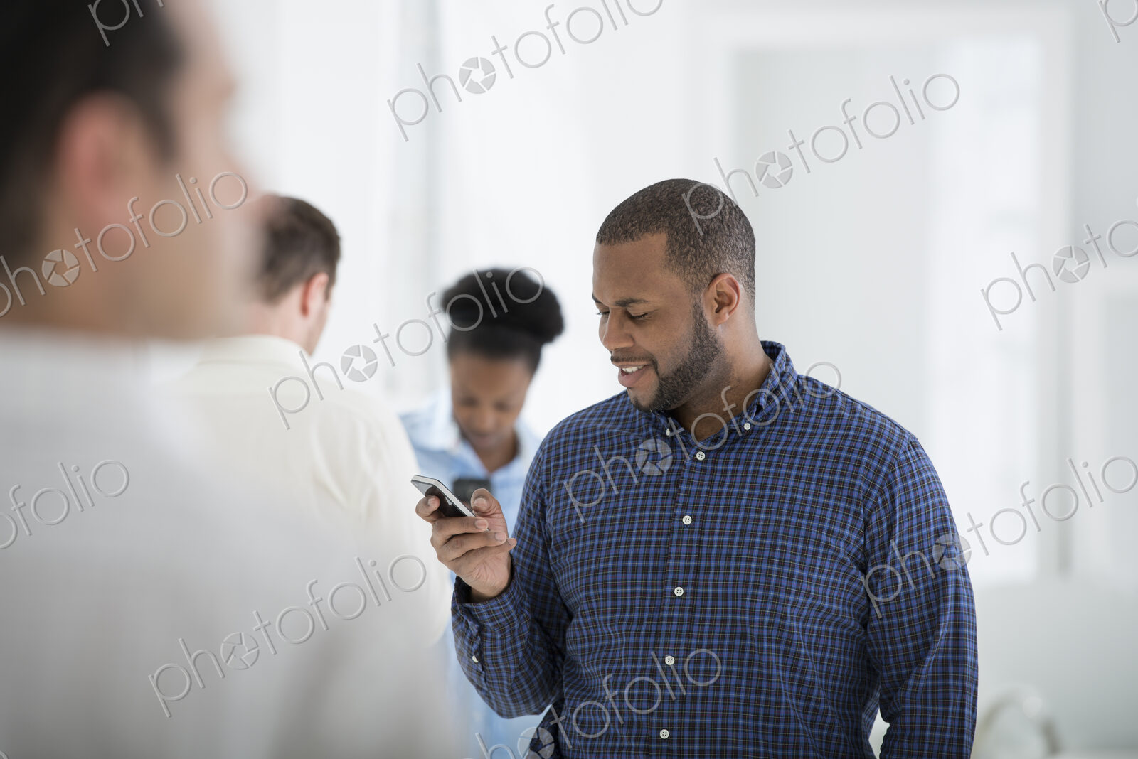 A fresh white building interior, flooded with light. A group of people, one man using…