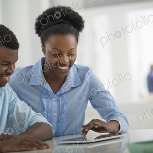 A fresh white building interior, flooded with light. A man and woman sitting side by…