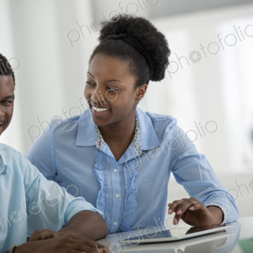 A fresh white building interior, flooded with light. A man and woman sitting side by…