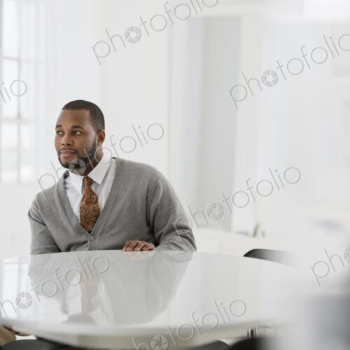 A fresh white building interior, flooded with light. A man in a business suit at a… A fresh white building interior, flooded with light. A man in a business suit at a…