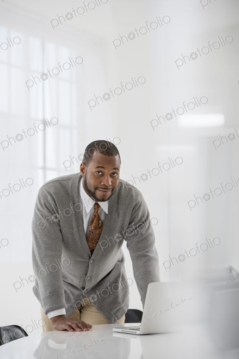 A fresh white building interior, flooded with light. A man in a business suit at a…