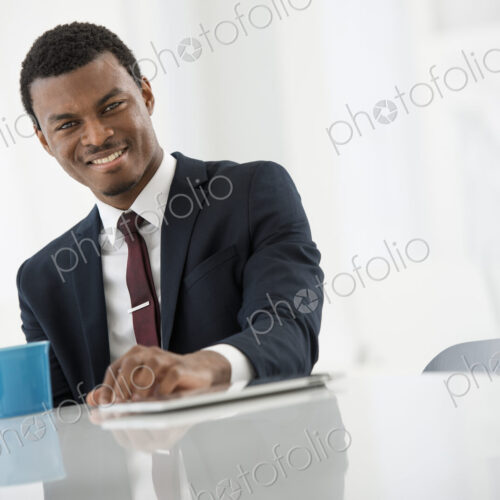 A fresh white building interior, flooded with light. A man in a suit with a cup of… A fresh white building interior, flooded with light. A man in a suit with a cup of…