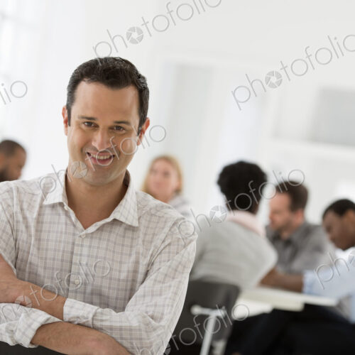 A fresh white building interior, flooded with light. A man seated separately from a… A fresh white building interior, flooded with light. A man seated separately from a…