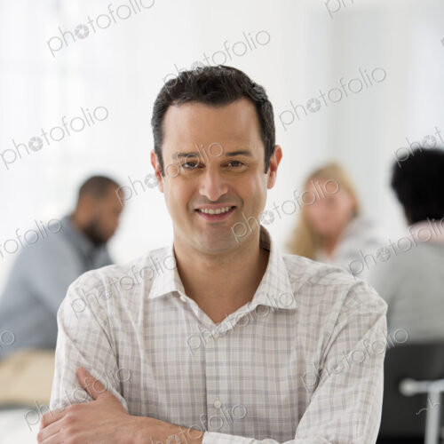 A fresh white building interior, flooded with light. A man seated separately from a… A fresh white building interior, flooded with light. A man seated separately from a…