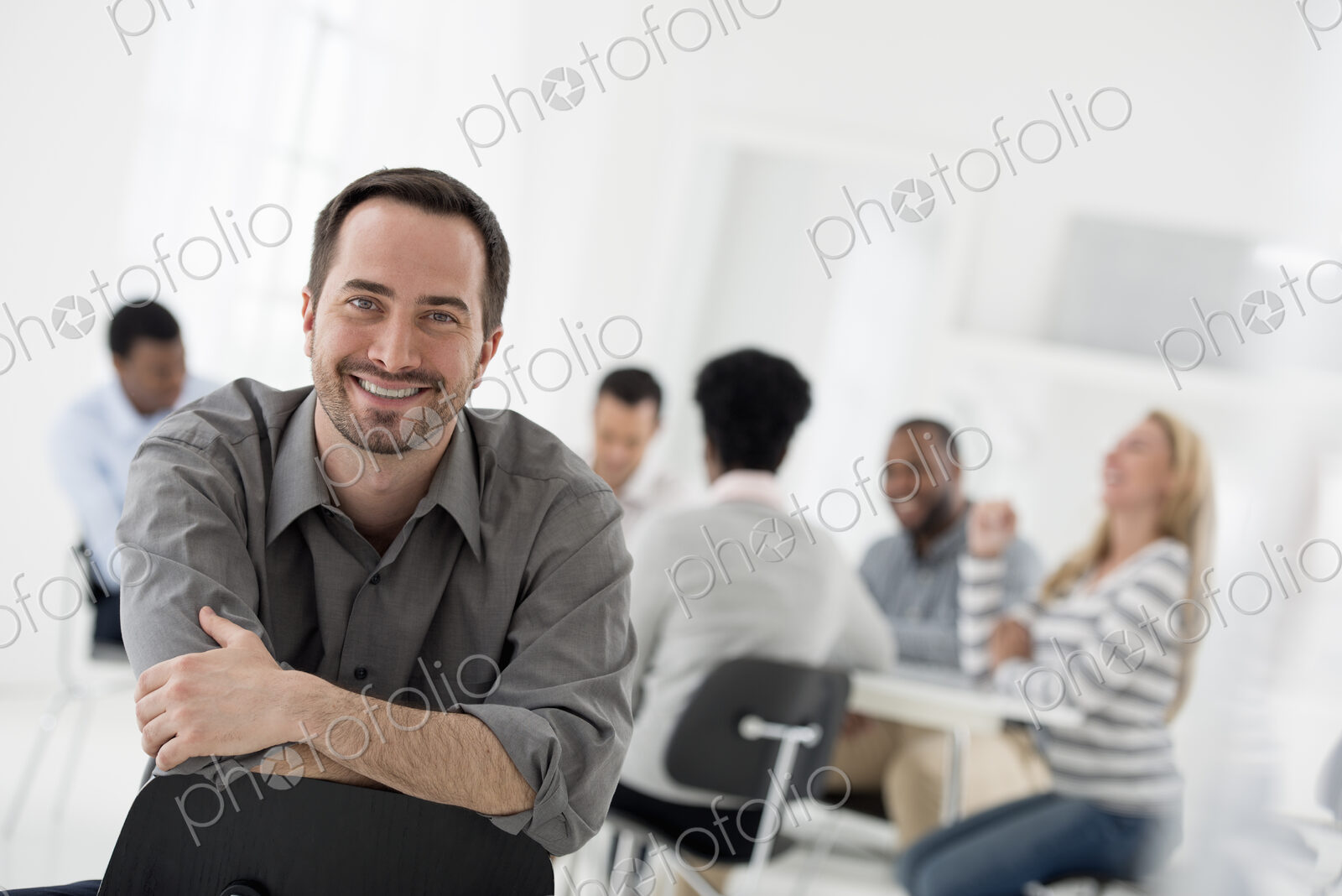 A fresh white building interior, flooded with light. A man seated with his armed…