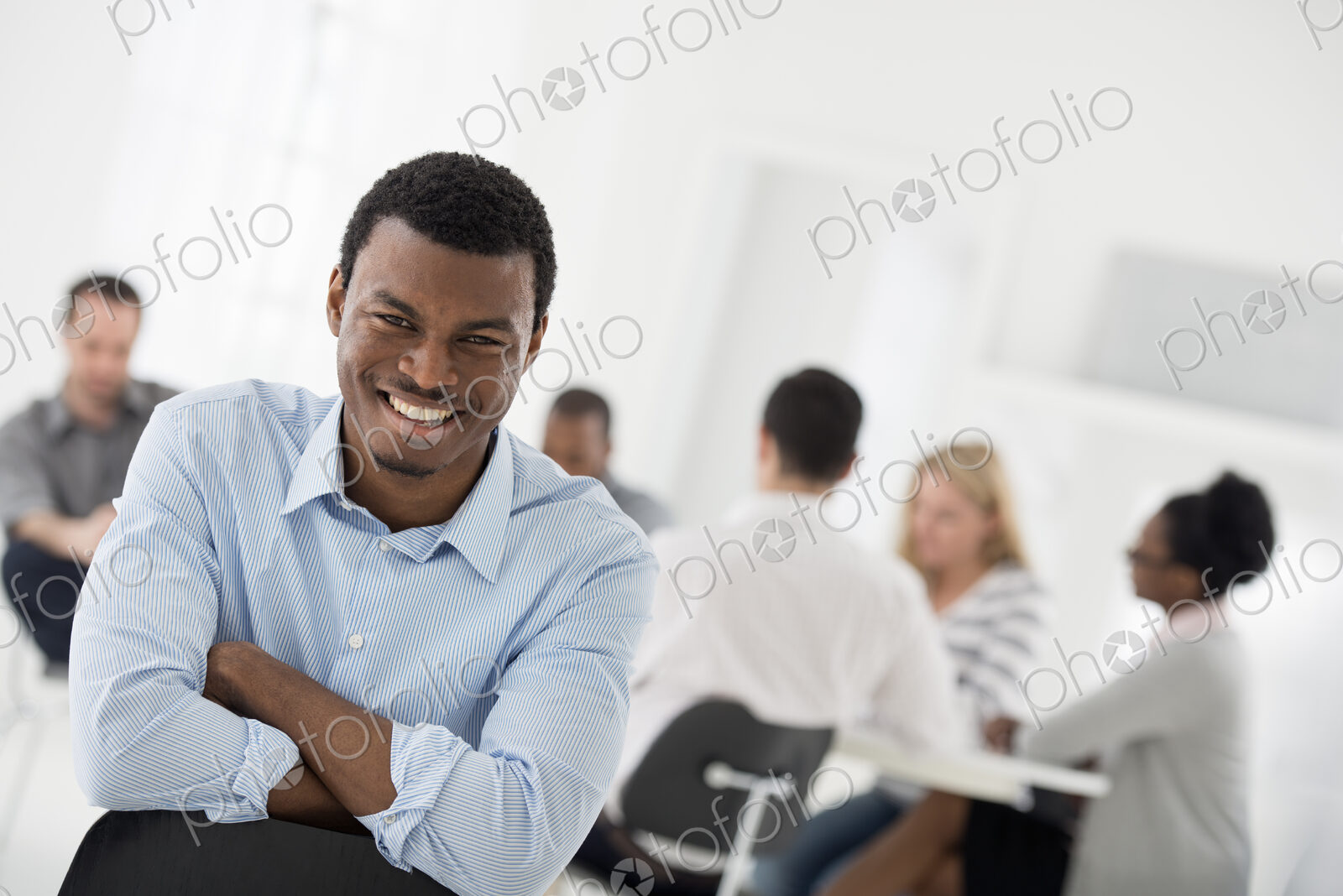 A fresh white building interior, flooded with light. A man seated with his armed…