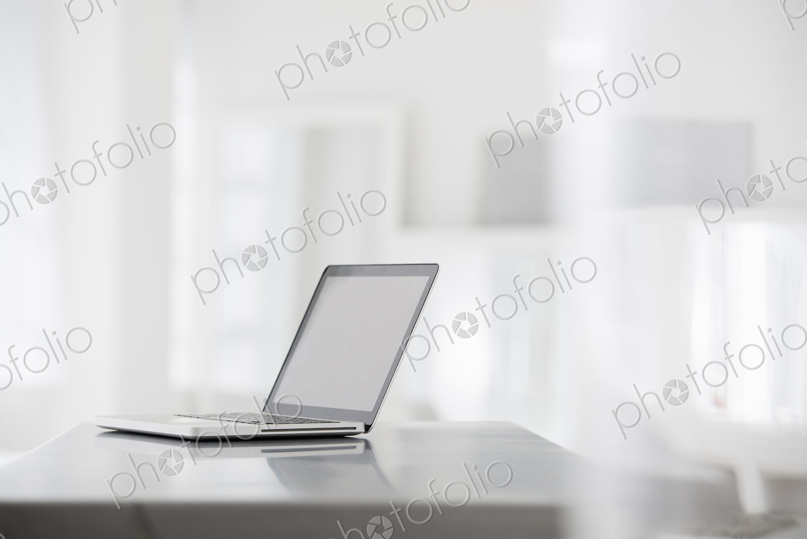 A fresh white building interior, flooded with light. A smooth shiny grey tabletop, and…