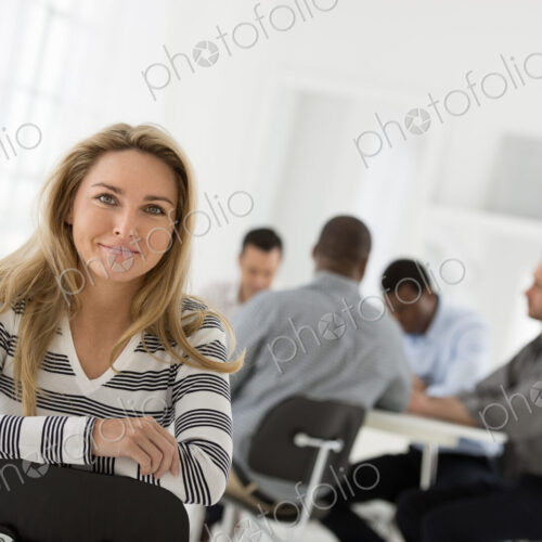 A fresh white building interior, flooded with light. A woman in a striped shirt seated… A fresh white building interior, flooded with light. A woman in a striped shirt seated…