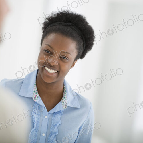 A fresh white building interior, flooded with light. A woman smiling and talking to a man.
