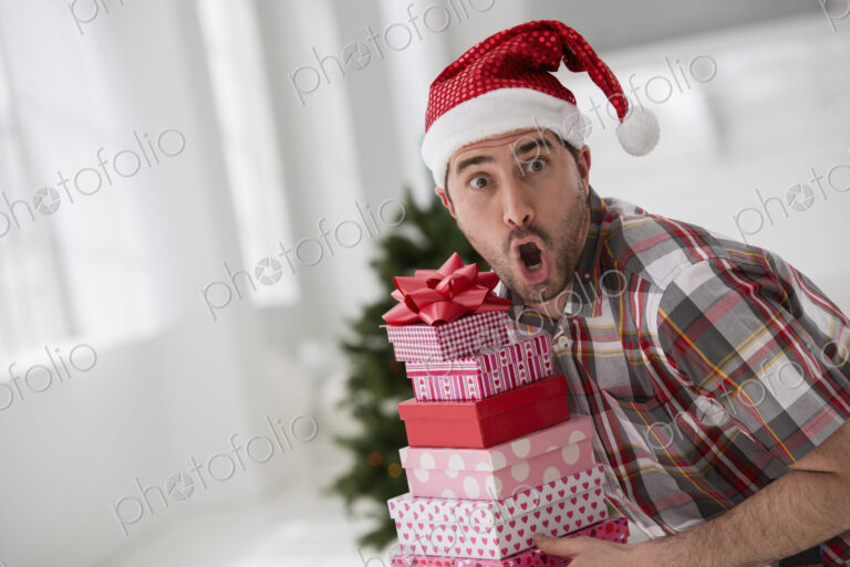 A fresh white building interior, flooded with light. Celebrating Christmas. A man in a…