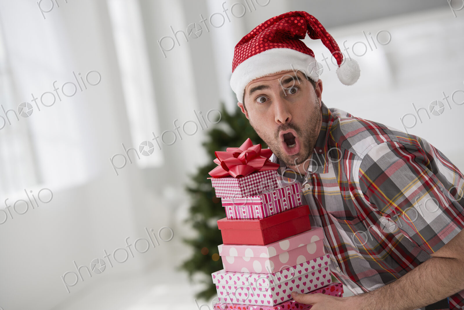 A fresh white building interior, flooded with light. Celebrating Christmas. A man in a…