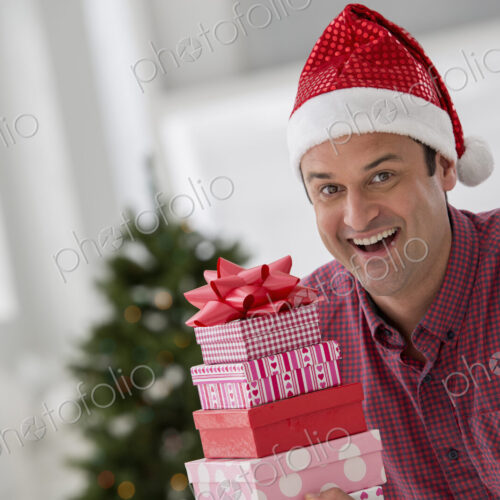 A fresh white building interior, flooded with light. Celebrating Christmas. A man in a… A fresh white building interior, flooded with light. Celebrating Christmas. A man in a…
