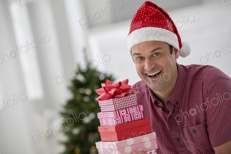 A fresh white building interior, flooded with light. Celebrating Christmas. A man in a…