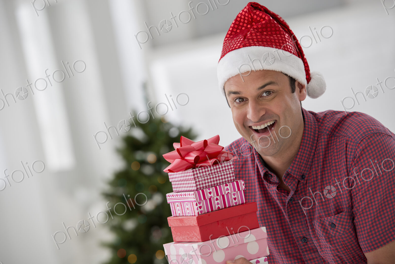 A fresh white building interior, flooded with light. Celebrating Christmas. A man in a…