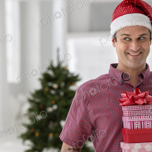 A fresh white building interior, flooded with light. Celebrating Christmas. A man in a… A fresh white building interior, flooded with light. Celebrating Christmas. A man in a…