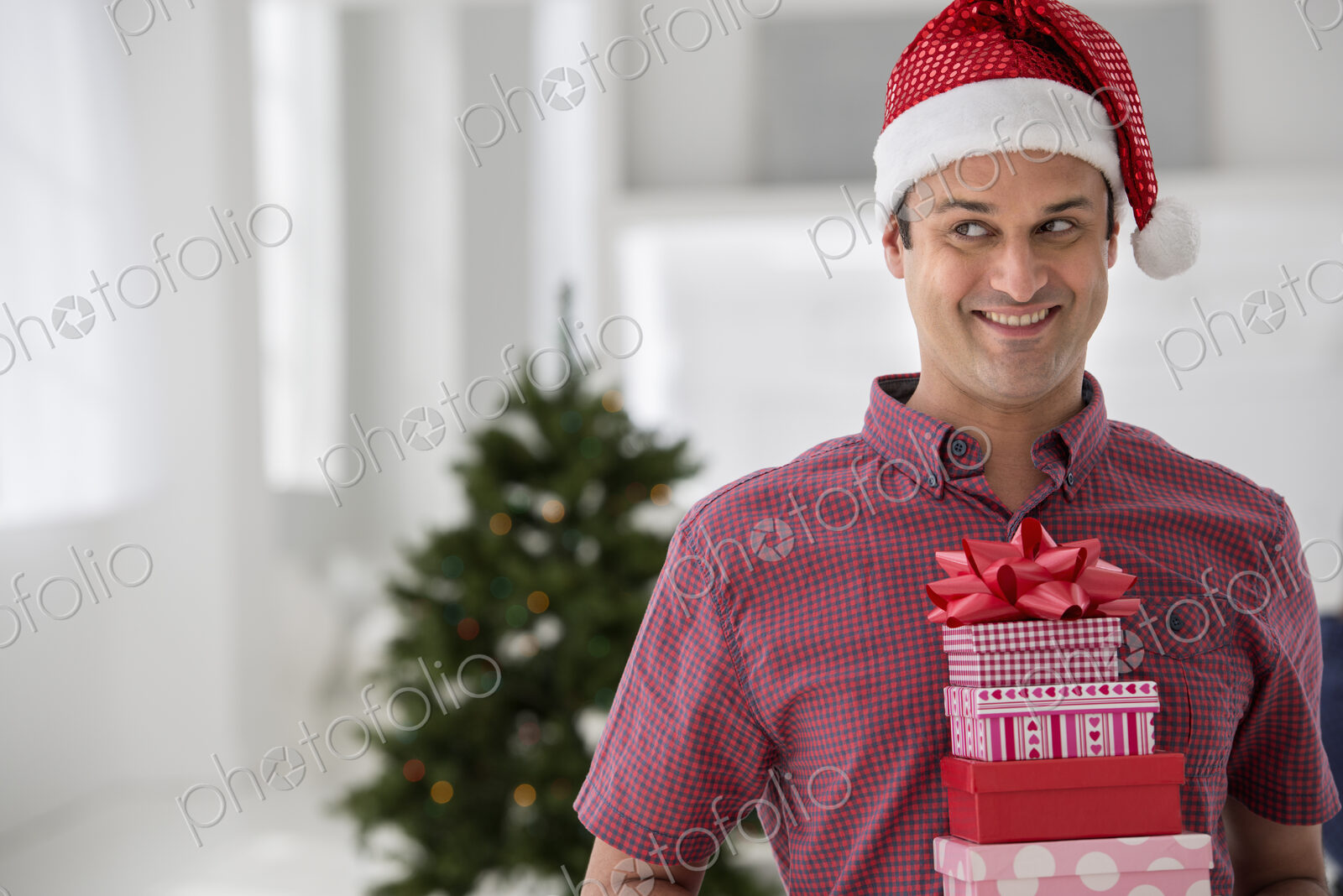 A fresh white building interior, flooded with light. Celebrating Christmas. A man in a…