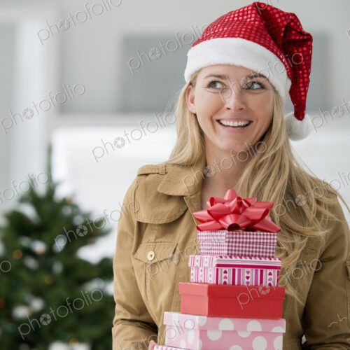 A fresh white building interior, flooded with light. Celebrating Christmas. A woman in… A fresh white building interior, flooded with light. Celebrating Christmas. A woman in…