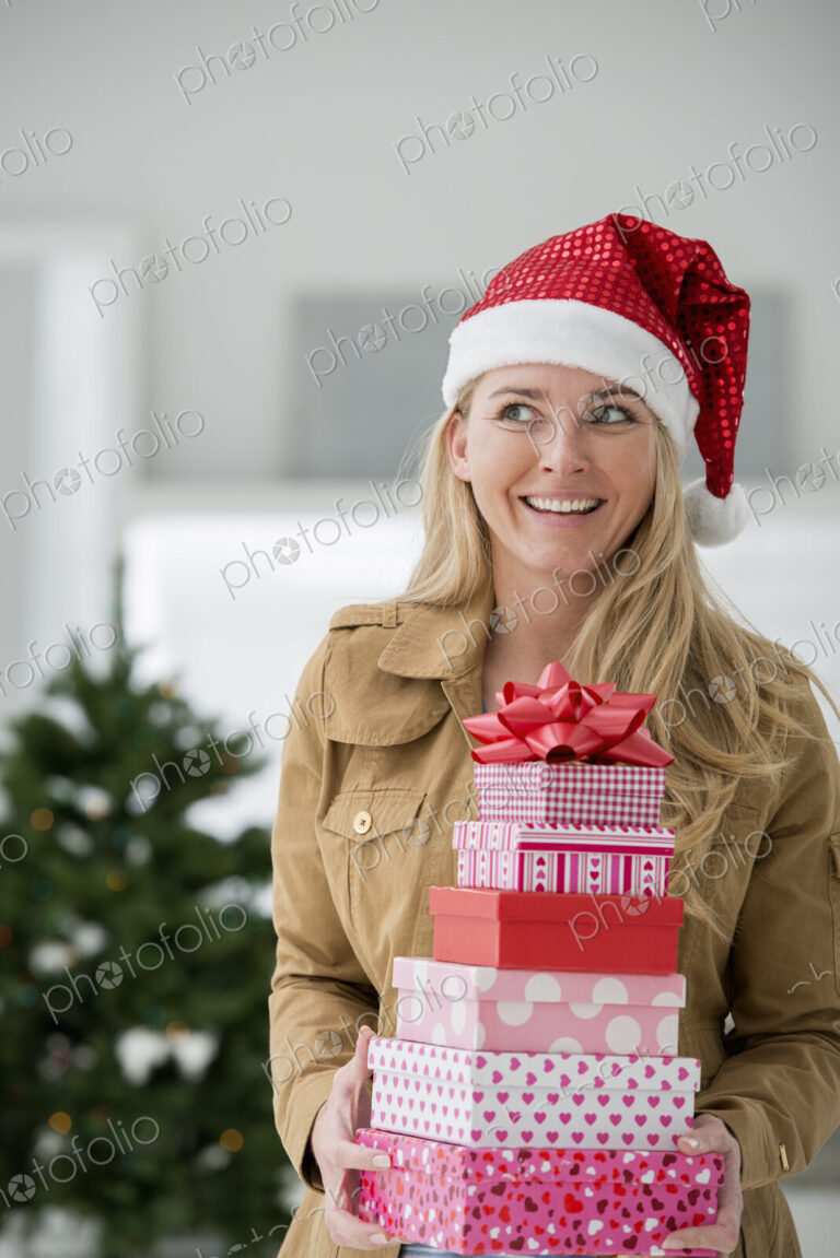 A fresh white building interior, flooded with light. Celebrating Christmas. A woman in…