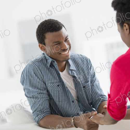 A fresh white building interior, flooded with light. Two people talking to each other,…